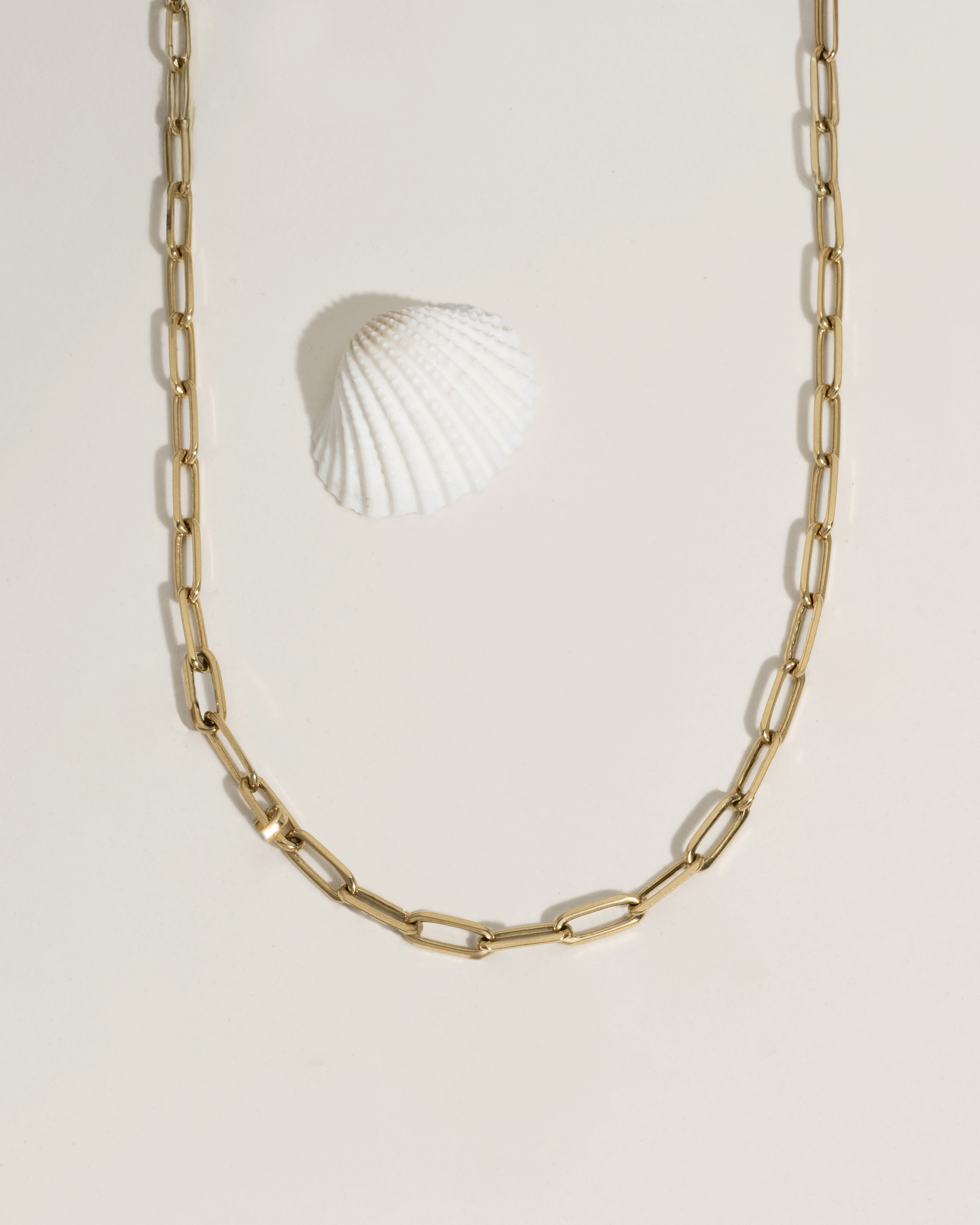 Animated GIF showing model wrist with stacked gold bracelets under flowing water, water resistance demo