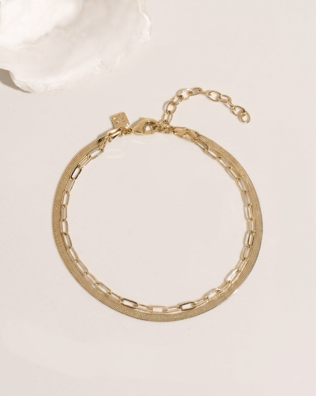 Two-layer gold anklet set combining flat herringbone chain and paperclip link chain, detail view