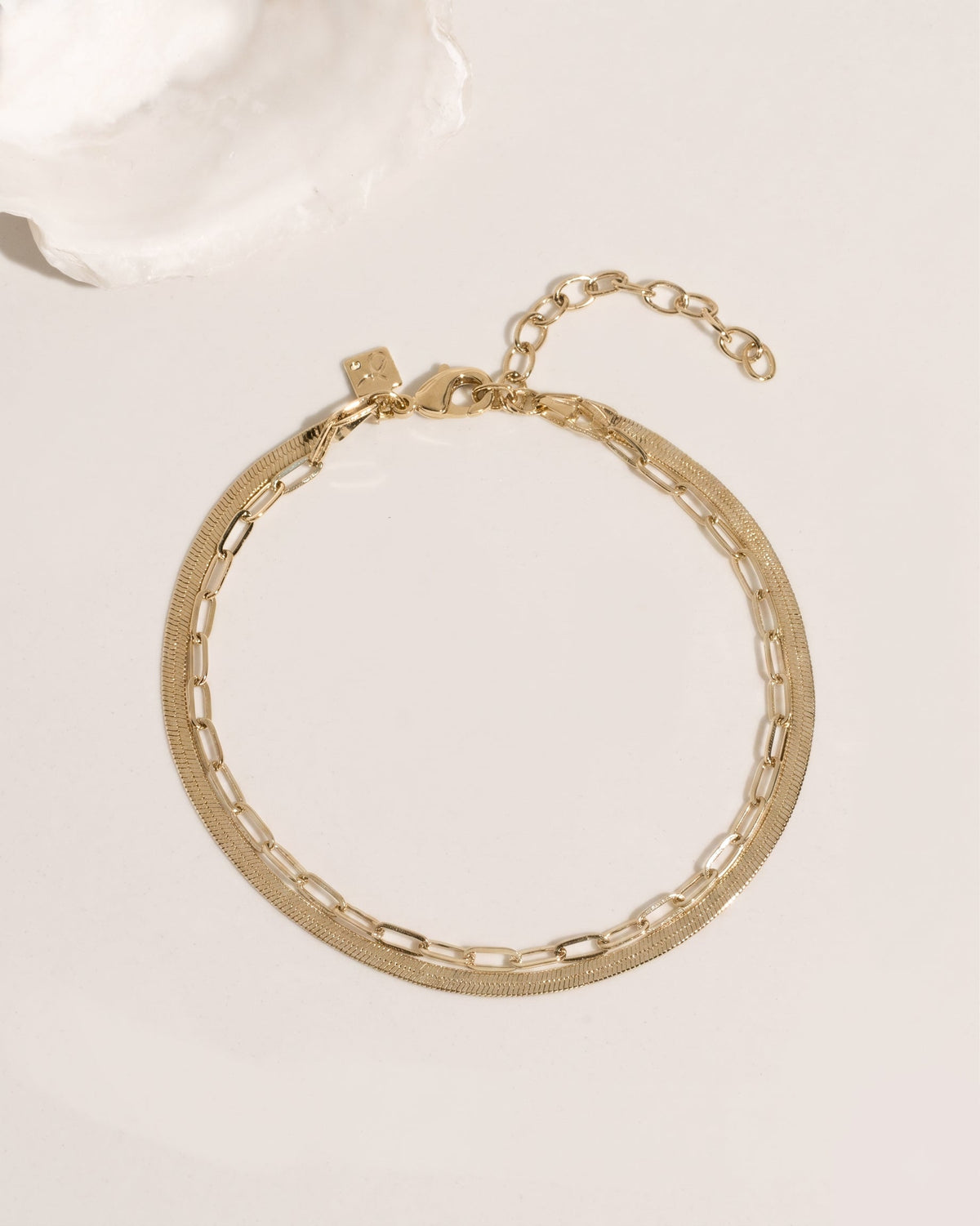 Two-layer gold anklet set combining flat herringbone chain and paperclip link chain, detail view