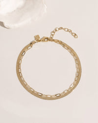 Two-layer gold anklet set combining flat herringbone chain and paperclip link chain, detail view
