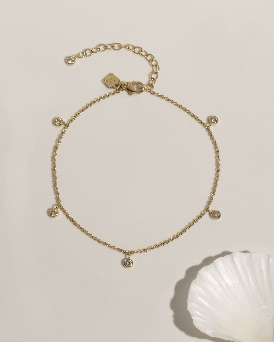 Delicate gold anklet with bezel-set crystal charm accent