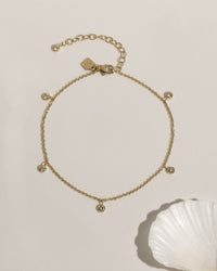 Delicate gold anklet with bezel-set crystal charm accent