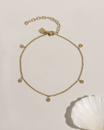 Delicate gold anklet with bezel-set crystal charm accent