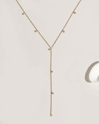 Gold lariat necklace with multiple bezel-set crystal charm drops on fine chain