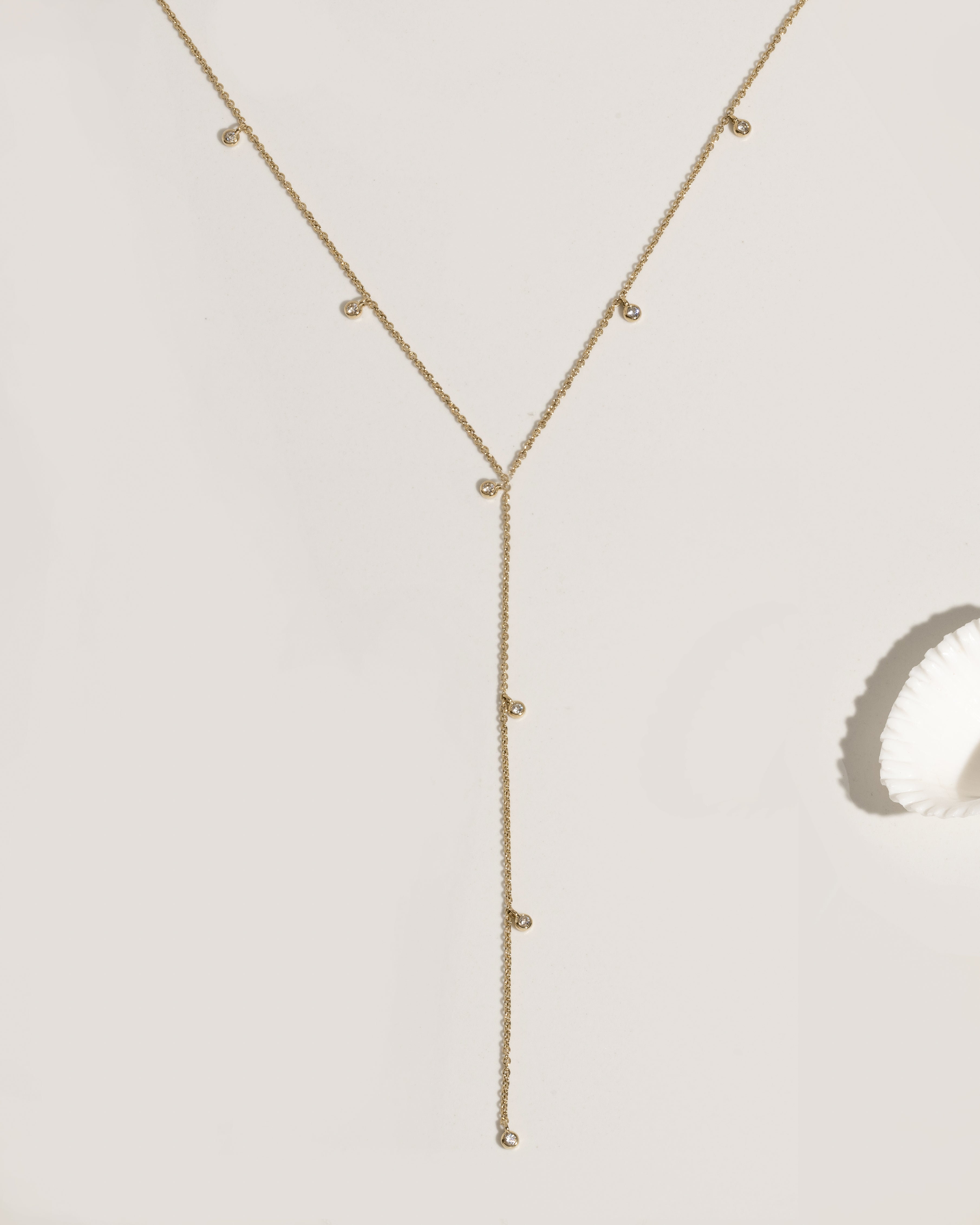 Gold lariat necklace with multiple bezel-set crystal charm drops on fine chain