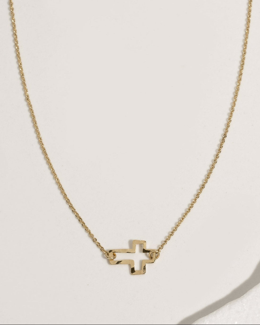 Delicate gold rolo chain necklace with tiny open cross pendant